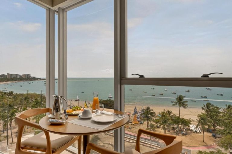 Mesa de desayuno con vista panorámica a la playa y mar en Venti Hotel By Brisa Hotéis