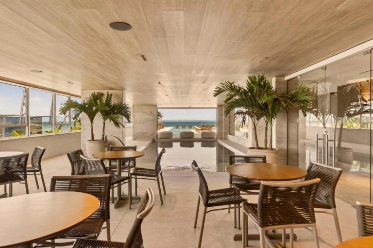 Terraza con mesas y sillas junto a la piscina infinita con vistas al mar en Venti Hotel by Brisa