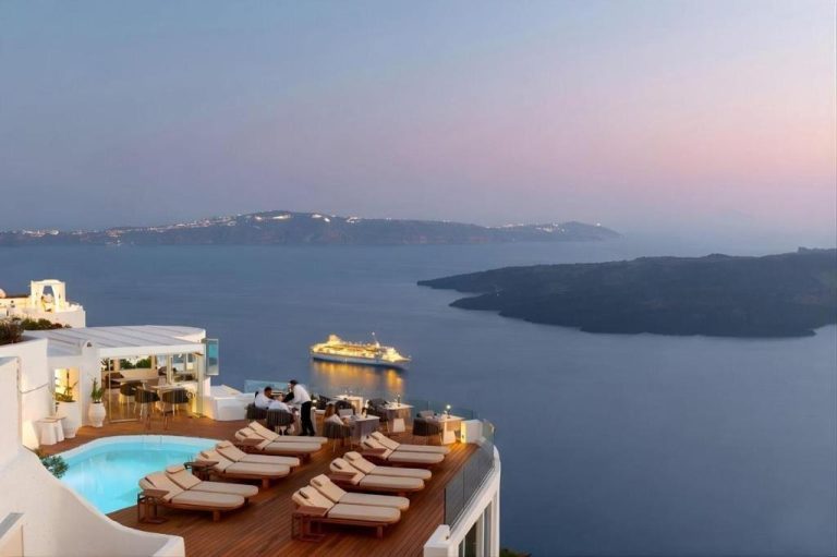 Terraza con piscina y tumbonas del Sun Rocks Boutique Hotel con vistas a la caldera de Santorini al atardecer
