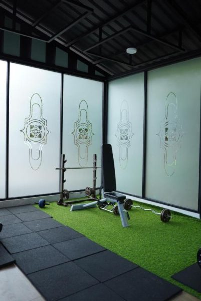 Gimnasio moderno con pesas y banco de musculación en Anaya Azana Hotel & Villa Tawangmangu