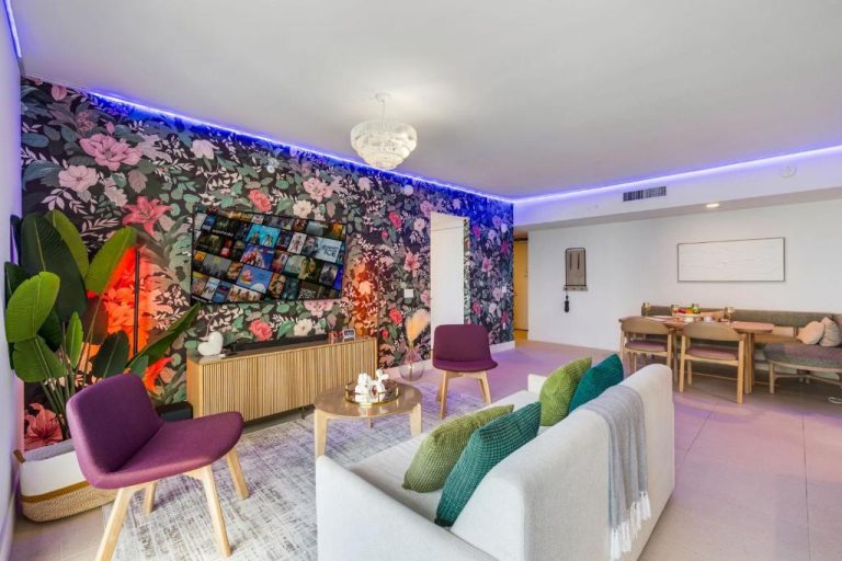 Salón moderno con pared floral, televisión de pantalla grande e iluminación LED azul en Stunning Lux 2 Bed 2 Bath