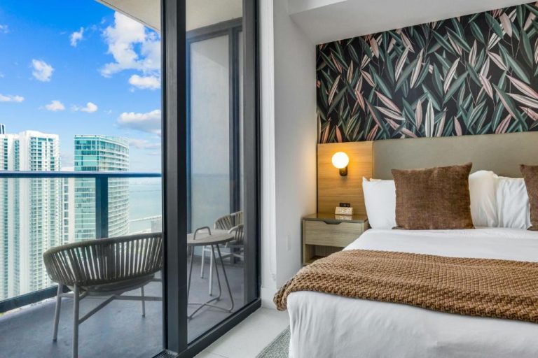 Habitación de lujo con cama doble, balcón y vistas panorámicas al mar y skyline en Stunning Lux 2 Bed 2 Bath