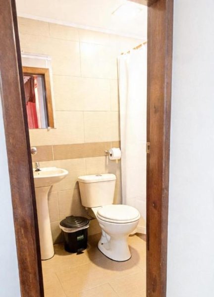 Baño completo con ducha, inodoro y lavabo del Hotel Girasol, revestido con azulejos beige