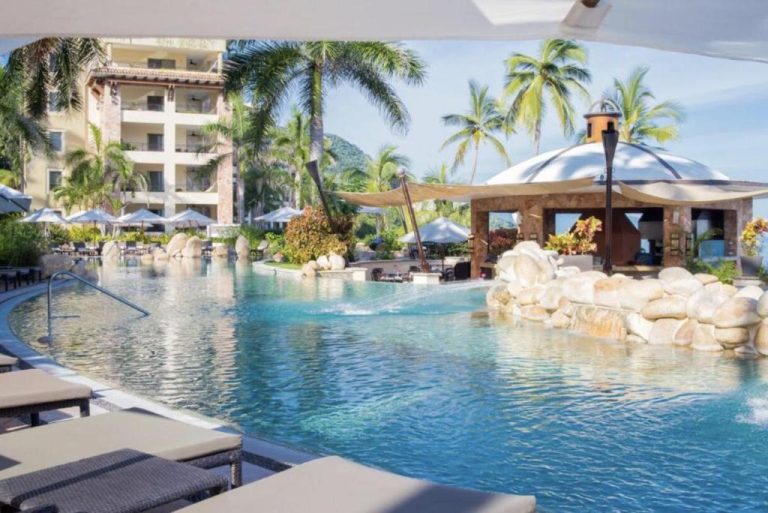 Piscina infinita con swim-up bar y palmeras del Garza Blanca Preserve Resort & Spa Puerto Vallarta