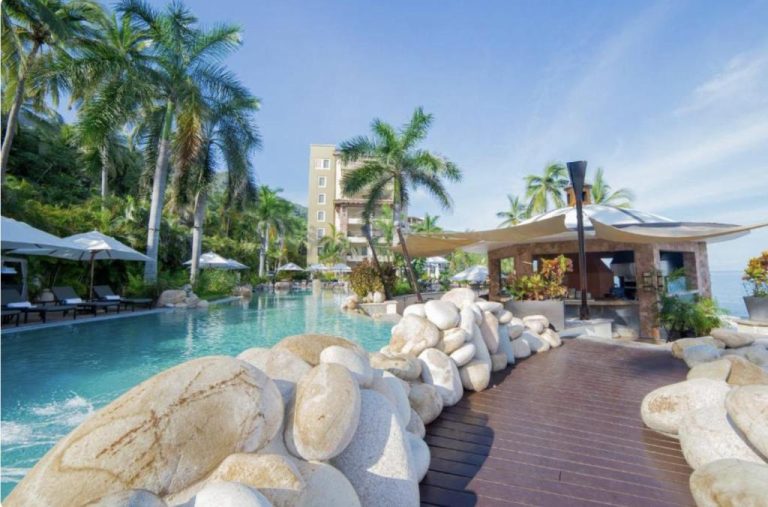 Piscina exterior con bar junto al mar y palmeras tropicales en Garza Blanca Preserve Resort & Spa Puerto Vallarta