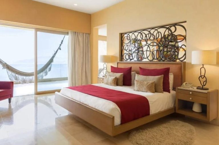 Habitación studio con cama king, decoración en rojo y beige, y terraza con hamaca frente al mar en Garza Blanca Preserve Resort & Spa Puerto Vallarta