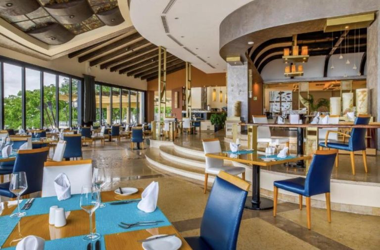 Elegante restaurante interior del Garza Blanca Preserve Resort & Spa Puerto Vallarta con mesas azules y sillas azules