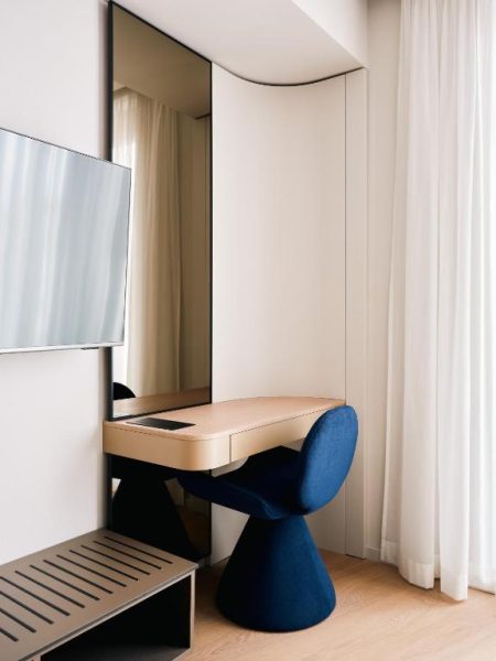 Escritorio de diseño con silla azul y espejo de cuerpo entero en Boutique Hotel Venturo Design Hotels