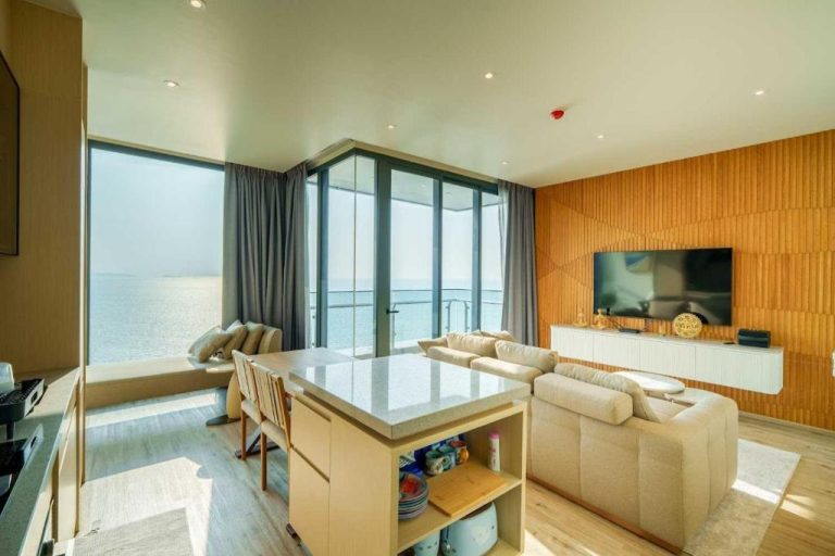 Salón moderno con vista panorámica al mar en Luxury 2BR Sea View Apartment con cocina isla y TV