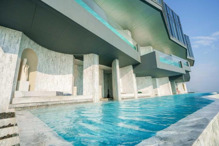 Piscina infinita exterior con cabanas de lujo y arquitectura moderna en Luxury 2BR Sea View Apartment
