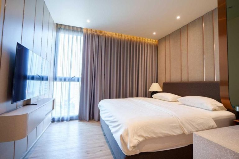 Habitación doble de lujo con cama king size, TV y ventanal en Luxury 2BR Sea View Apartment