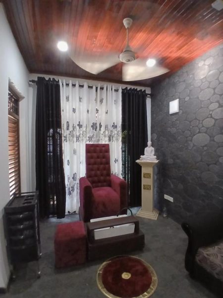 Lujosa sala de estar con sillón rojo y estatua de Buda en Polo the Beach Villa
