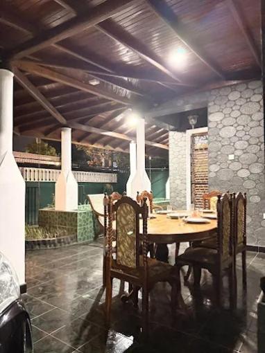 Comedor rústico de lujo con mesa de madera tallada y techo de vigas en Polo The Beach Villa