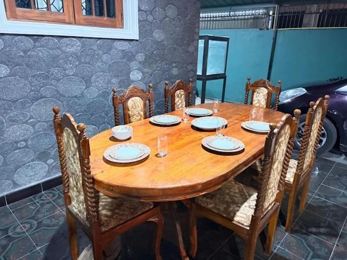 Comedor de lujo con mesa y sillas de madera tallada en Polo The Beach Villa, elegante sala de estar