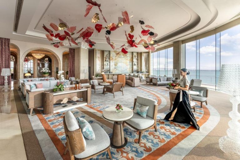 Elegante lobby lounge con vistas al mar y decoración artística del techo en NUSTAR Hotel Cebu