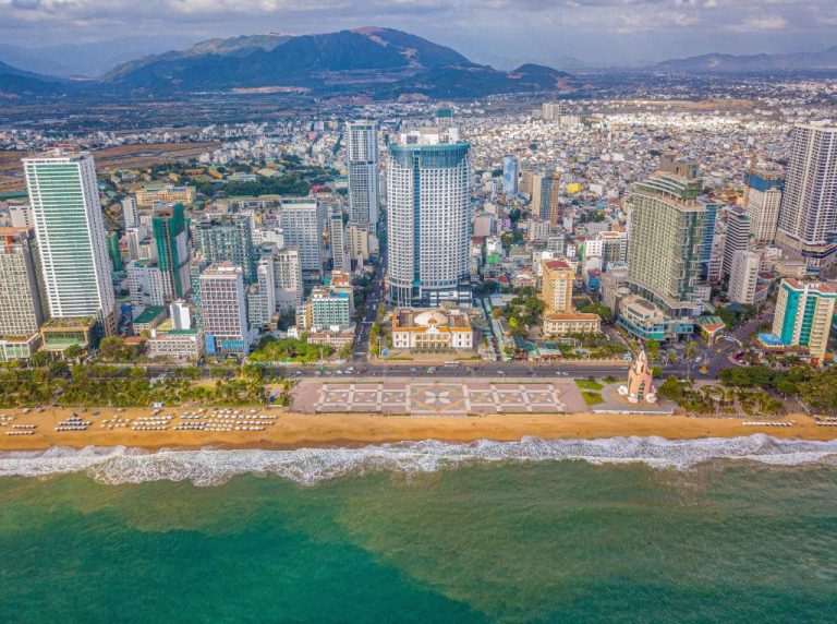 Vista aérea del The Maya Suites Seaview con playa, paseo marítimo y skyline de la ciudad al fondo