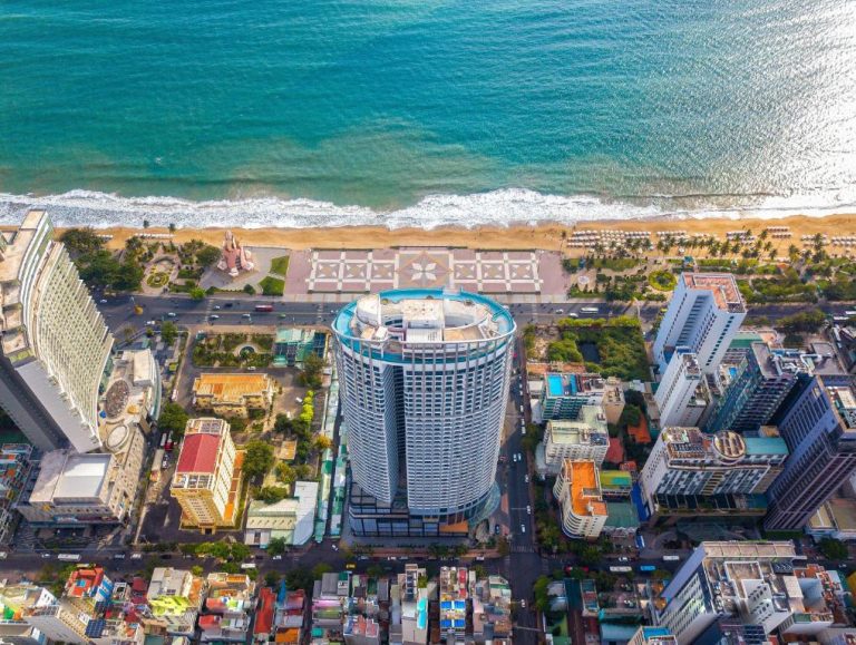 Vista aérea del The Maya Suites Seaview con torre frente al mar y playa de arena turquesa