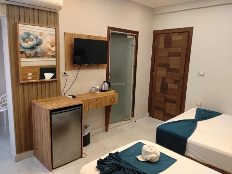 Habitación doble con dos camas, televisión, minibar y escritorio de madera en Up Town Crown Hotel