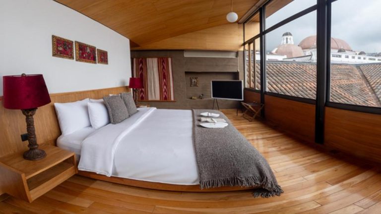 Suite de lujo con cama king y vistas panorámicas a cúpulas coloniales en Casa Santa Clara Boutique Hotel