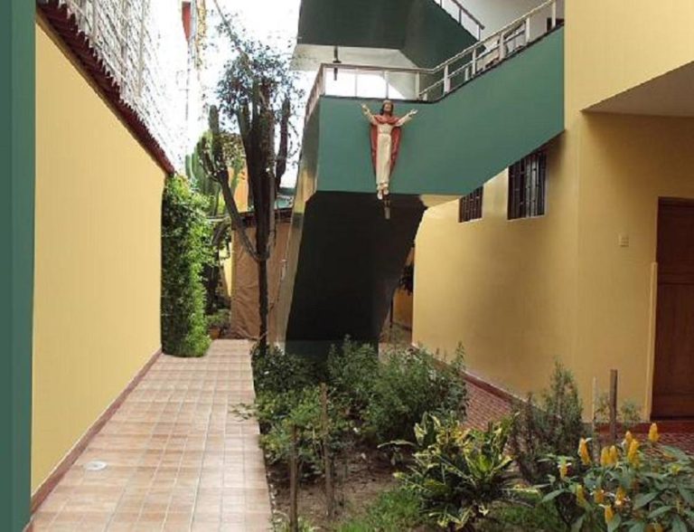 Patio interior con jardín y estatua religiosa del Hospedaje Del Pilar en Magdalena del Mar