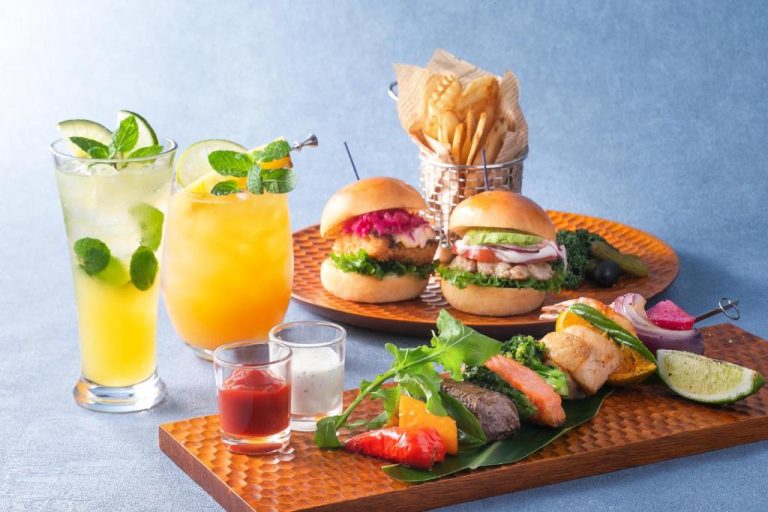 Selección gastronómica del Okinawa Harborview Hotel con hamburguesas, brochetas, patatas fritas y cócteles tropicales