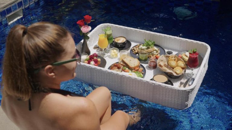 Desayuno flotante con frutas, panes y bebidas tropicales en la piscina del Vira Bali Boutique Hotel