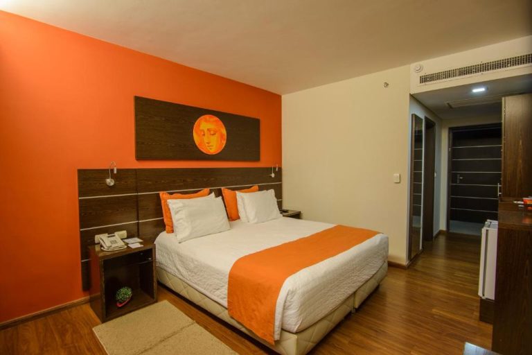 Habitación doble con decoración en tonos naranja y cama king size en Awa Resort Hotel