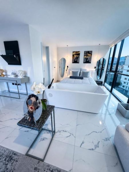 Suite de lujo con bañera exenta y cama doble en NIDO Boutique Hotel con suelo de mármol