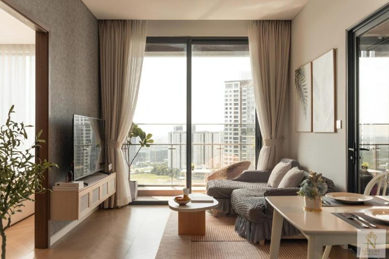 Salón moderno con sofá, mesa de centro y amplia terraza con vistas a la ciudad en Lumière Royal Sky Residence