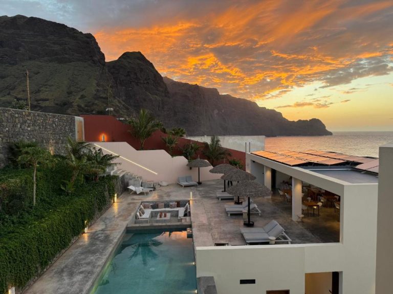 Piscina exterior con terraza y vistas al mar y acantilados del Walhalla Seahouse al atardecer