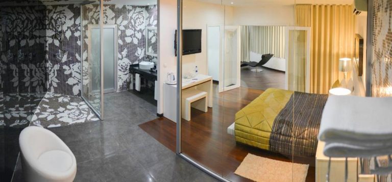 Suite de lujo con baño acristalado y dormitorio moderno en el Hotel Vip Praia