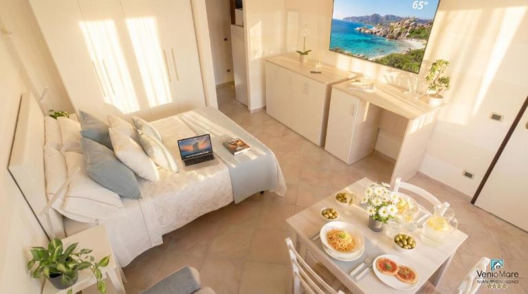 Estudio moderno con cama doble, mesa de comedor y TV 65 pulgadas en Sea Wind Apartments & Suites