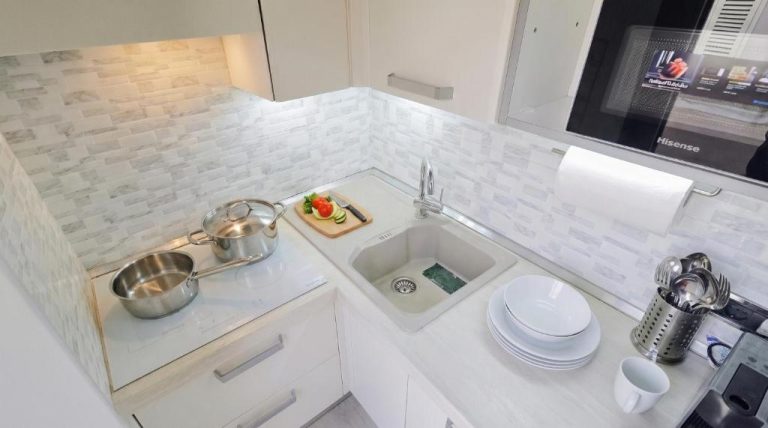 Cocina moderna totalmente equipada con fregadero, vitrocerámica y microondas en Sea Wind Apartments & Suites