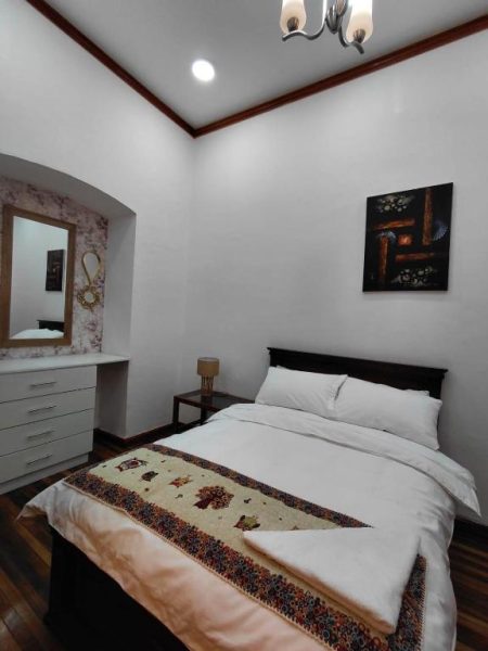 Habitación doble con cama matrimonial y decoración andina en Rossa Mia Hotel Boutique