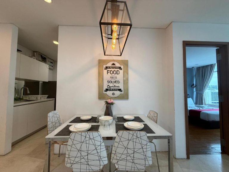 Comedor moderno con mesa blanca y cocina abierta en el Vortex KLCC Apartment de Kuala Lumpur