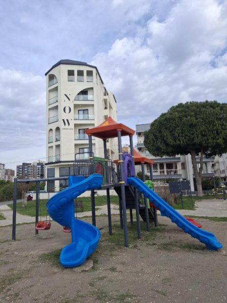 Zona de juegos infantiles con toboganes azules frente al Now Boutique Hotel