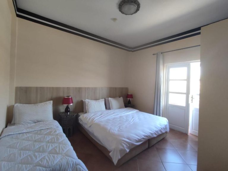 Habitación triple del BananaHouse con cama doble, cama individual y lámparas rojas
