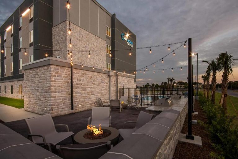 Terraza exterior con hoguera y luces decorativas del Everhome Suites Panama City Beach al atardecer