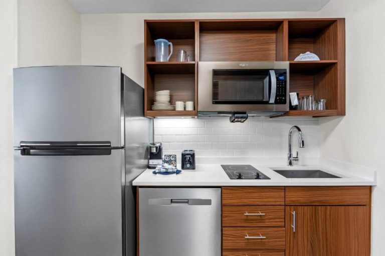 Cocina totalmente equipada con nevera, microondas y encimera en Everhome Suites Panama City Beach