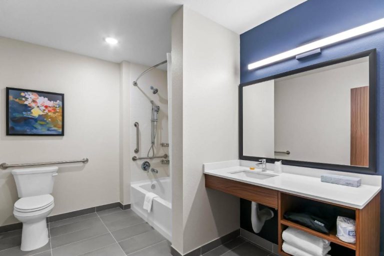 Baño accesible con bañera adaptada y barras de apoyo en Everhome Suites Panama City Beach