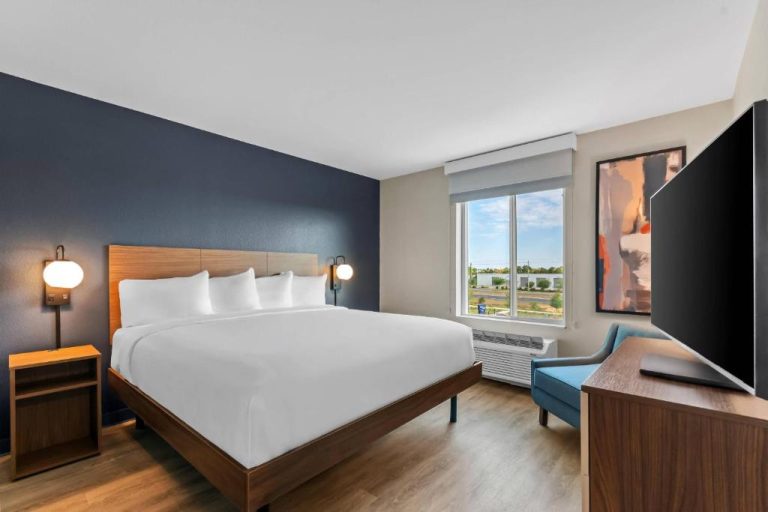 Habitación king con cama doble, televisión y vistas exteriores en Everhome Suites Panama City Beach