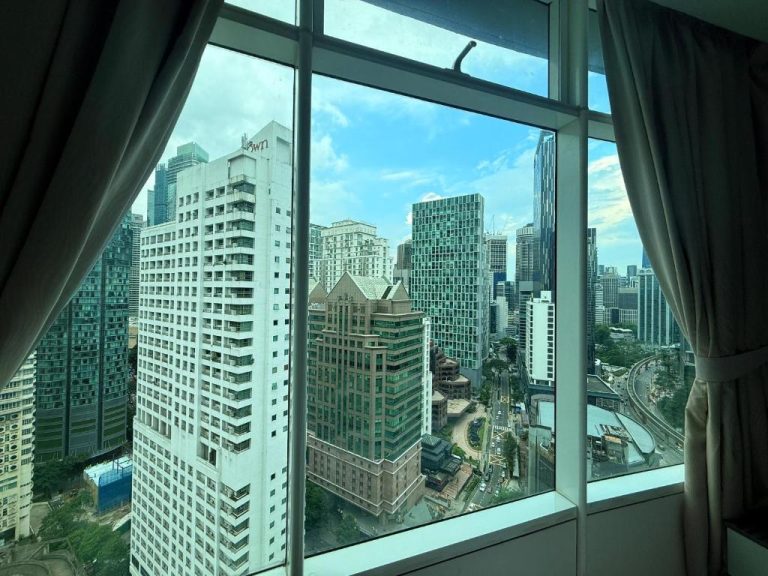 Vista panorámica del skyline de Kuala Lumpur desde ventana del Vortex KLCC Apartment con rascacielos
