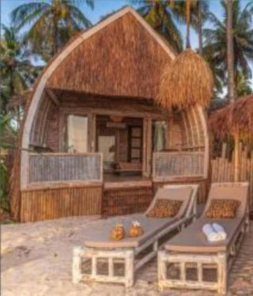 Cabaña de paja con tumbonas en la playa del VeriDiana Hotel Zanzibar rodeada de palmeras