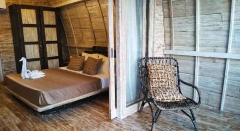 Habitación rústica con cama doble y silla de ratán en VeriDiana Hotel Zanzibar