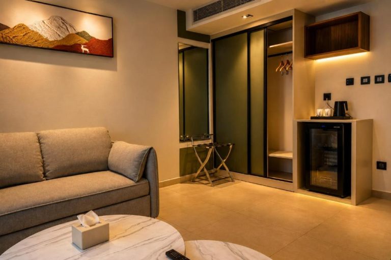 Salón elegante con sofá y minibar en suite del Coral Beach Hotel & Spa