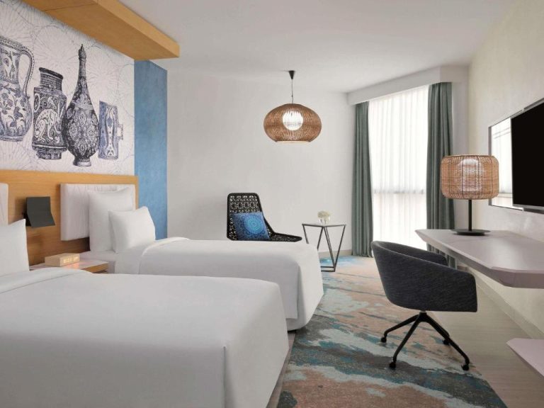 Habitación twin con decoración árabe y dos camas en Mövenpick Hotel Ghala Muscat