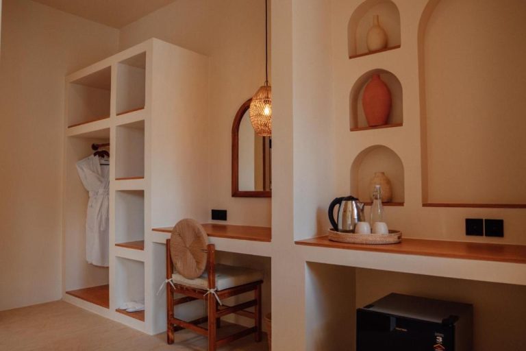 Habitación con escritorio de madera, nichos decorativos y zona de armario en Miliyana Boutique Hotel Adults Only