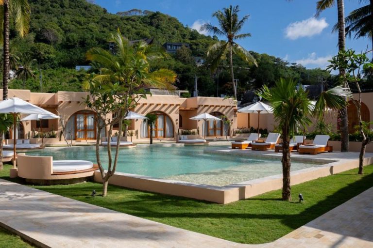 Piscina exterior con tumbonas y sombrillas del Miliyana Boutique Hotel Adults Only rodeada de palmeras