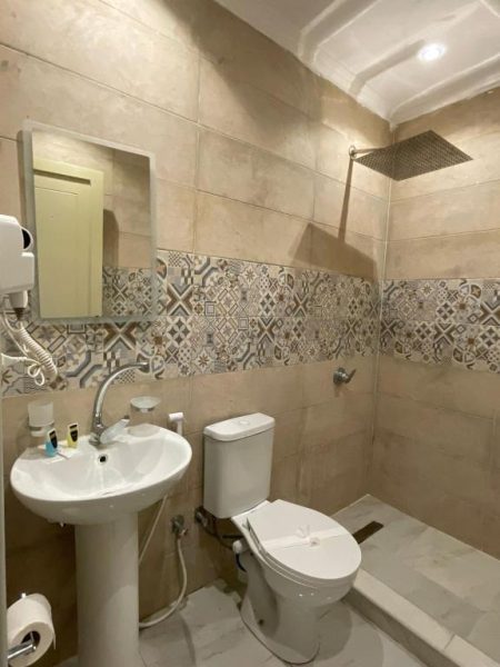 Baño completo con ducha de lluvia, lavabo y WC en Garden Hotel El Tahrir Downtown El Cairo