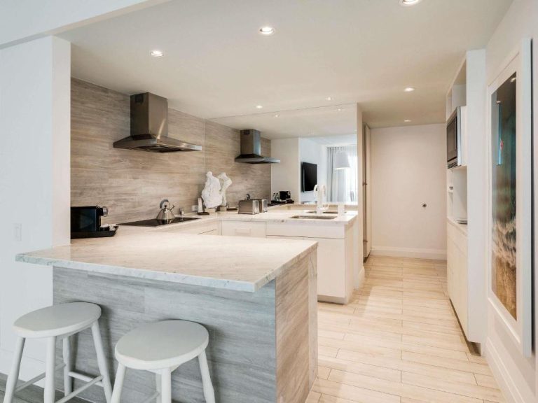 Cocina moderna totalmente equipada con isla central y encimera de mármol en el SLS Baha Mar